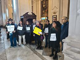 Oda, la protesta in chiesa: i lavoratori mostrano i cartelli all'arcivescovo durante la messa